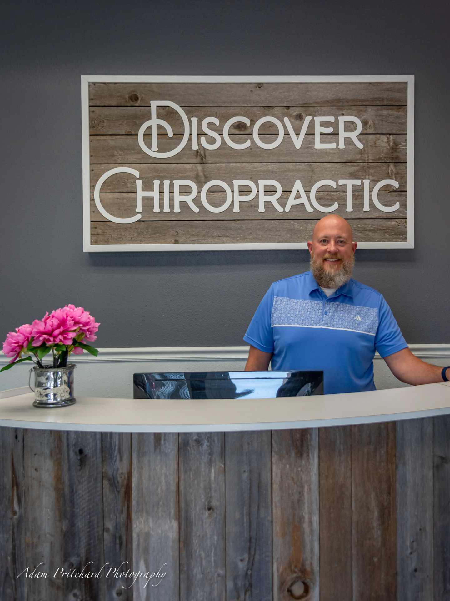 Dr. Seth Anderson at the front desk of Discover Chiropractic in University Place, Washington